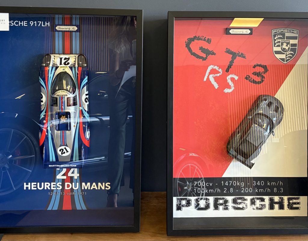 Deux cadres avec des voitures miniatures de la marque Porsche